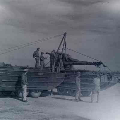 Soldiers loading artillery into DUKW