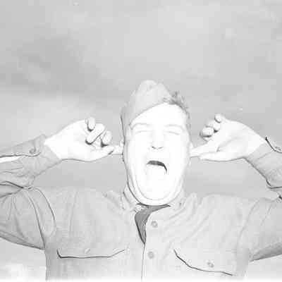 Shouting soldier with his fingers in his ears