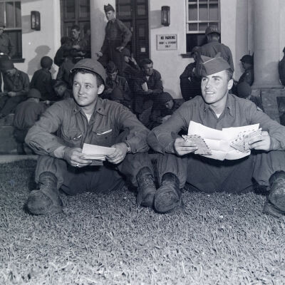 Two soldiers reading letters from home