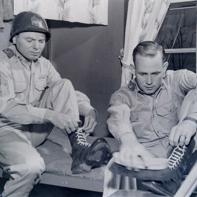 Soldiers using white laces to lace-up their boots