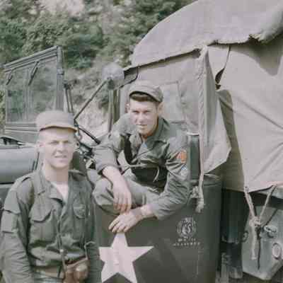 Two soldiers next to Army truck
