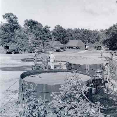 Water storage tanks with camp tents in background