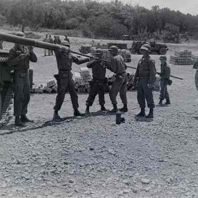 Soldiers cleaning the main tube on a tank
