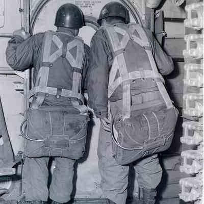 Two paratroopers looking out the window of a C-119