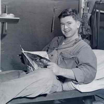 Soldier reading a magazine on his bunk