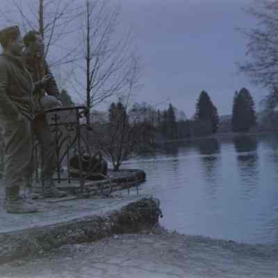 Two soldiers talking by a pond