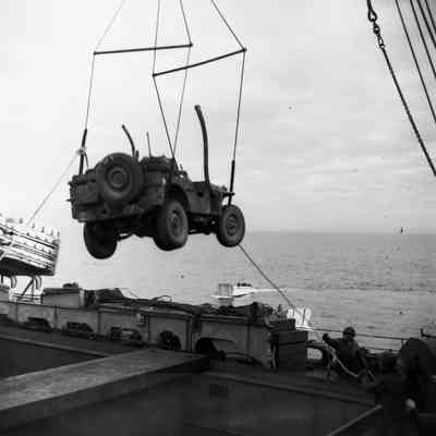 Soldiers loading Jeep into landing craft