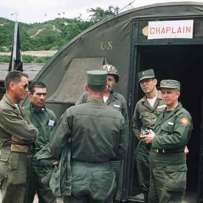 Chaplains talking in front of tent