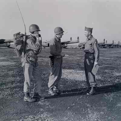 Officers and radioman on flightline with aircraft in background