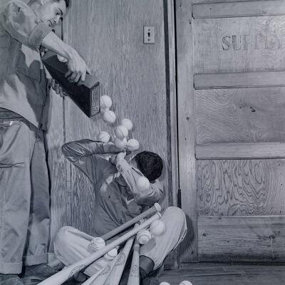 Soldier pouring baseballs on another soldier