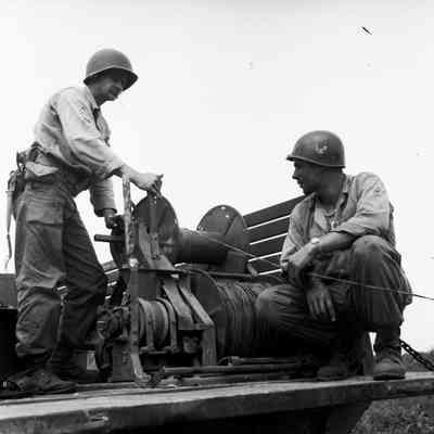 Soldiers stringing commo wire from back of truck