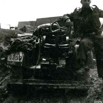 Soldier posing with destroyed vehicle