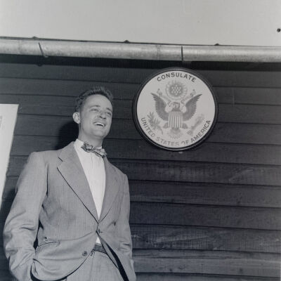 Civilian standing in front of a US Consular Seal