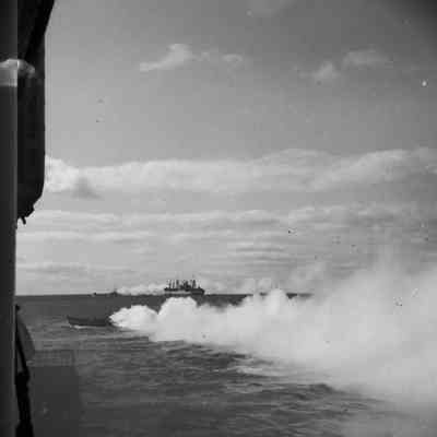 Landing craft lay smokescreen at sea