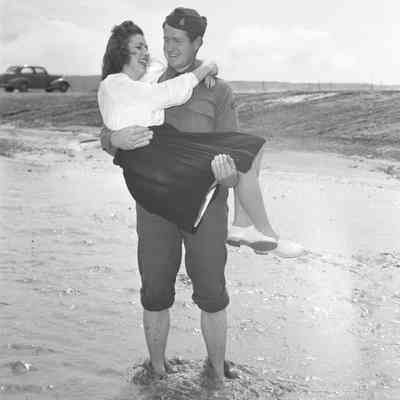 Soldier carrying a girl across a flooded drainage ditch