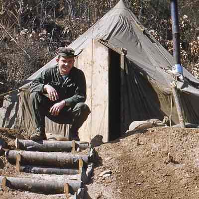 Soldier posing in front of his tent