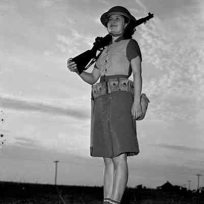 Girl holding a rifle and wearing a helmet and pistol belt