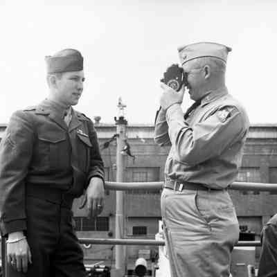 Chaplain filming a soldier onboard ship