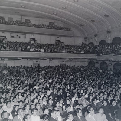 Large civilian audience in a theater