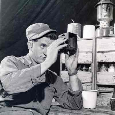 Soldier examining a piece of gear in a repair shop