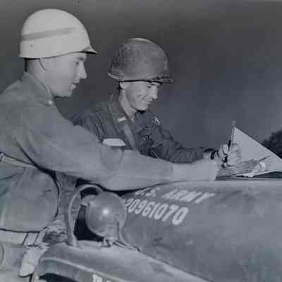 Soldiers examining a map on the hood of a jeep