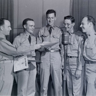Five soldiers around a microphone