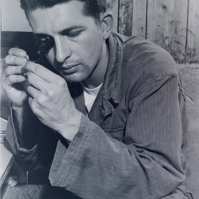 Soldier examining a very small object with a loupe
