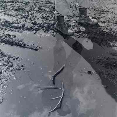 Reflection of a soldier in a mud puddle