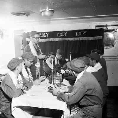 Jewish soldiers on ship seated at table for religious ceremony
