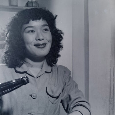 Japanese woman pouring a bottle into a glass