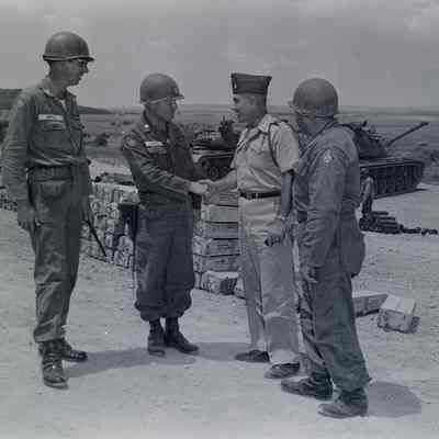 Group of officers shaking hands behind the tank practice range
