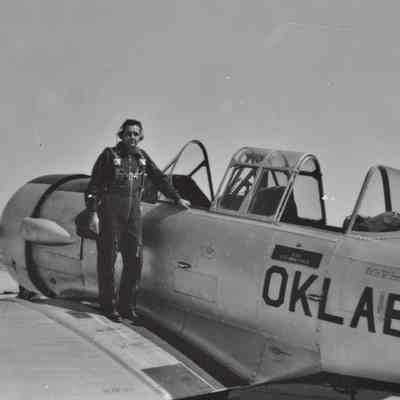 Pilot stands on the wing of a T-6 Texan