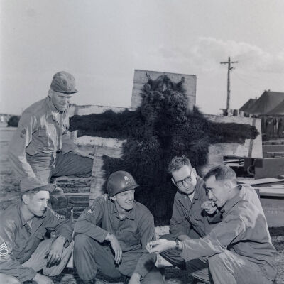 Group of soldiers listening to another soldier explain how he shot a bear