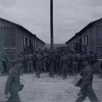 Soldiers crowing around camp buildings
