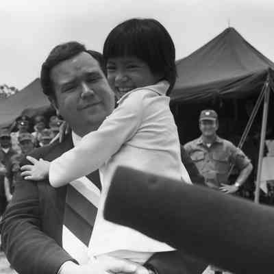 Govenor David Boren holding refugee child from Vietnam