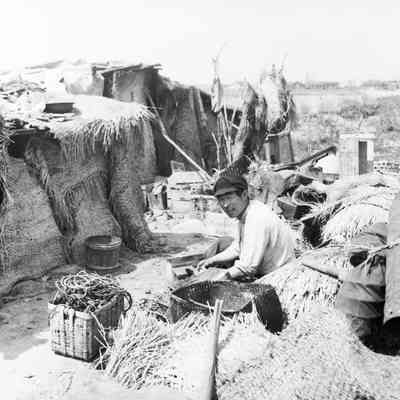 Japanese man in front of his makeshift shelter