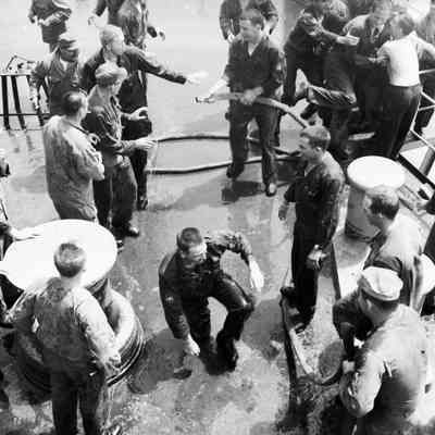 Soldiers hosing each other down onboard ship