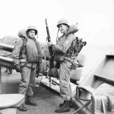 Soldiers on deck wearing life vests and helmets