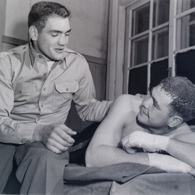 Boxer and soldier sitting on cot