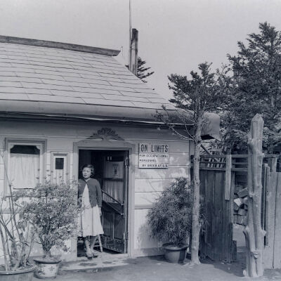 Japanese woman standing in doorway of a small business
