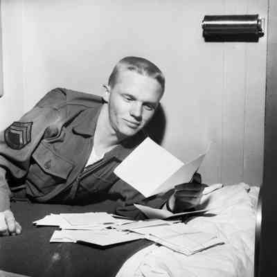 Soldier reading mail on cot