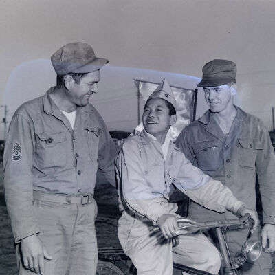 Two soldiers with Japanese boy on bicycle
