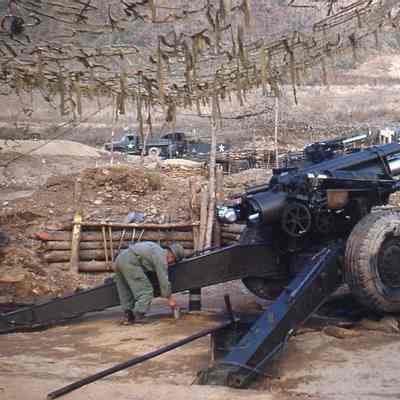 Soldier with camouflaged artillery gun