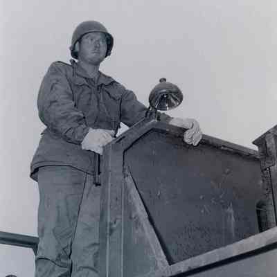 Soldier standing on a large vehicle