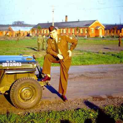 Soldier posing next to a jeep