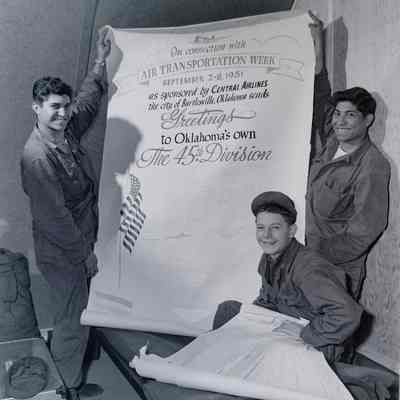 Soldiers holding poster celebrating "Air Transportation Week"