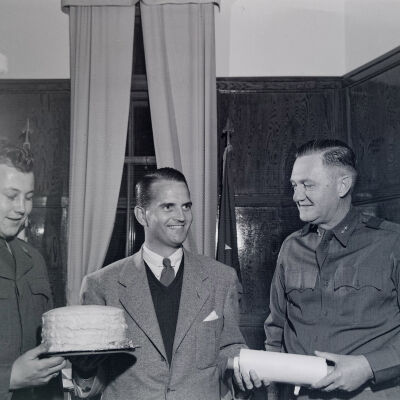 General Styron and Congressman John Jarman giving a cake to a soldier