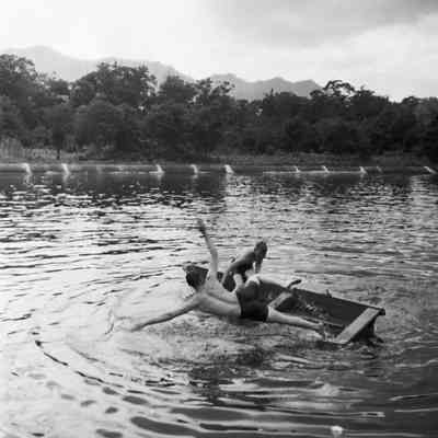 Soldiers falling off a rowboat into a lake