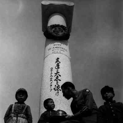 Soldier and kids in front of monument to W. S. Clark at Sapporo Agricultural College