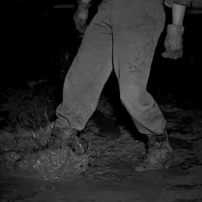 Soldier sloshing his boots in a mud puddle